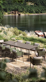 Load image into Gallery viewer, Cesto chairs arranged around outdoor dining table — lakeside terrace setting — Minosé