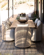 Load image into Gallery viewer, Corda hand-woven outdoor dining chairs surrounding dark rectangular table on sunlit terrace — natural rope texture and cream linen upholstery — Minosé
