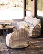 Load image into Gallery viewer, Corda outdoor lounge seating with curved hand-woven rope exterior and cream linen cushions on modern wooden terrace — Minosé
