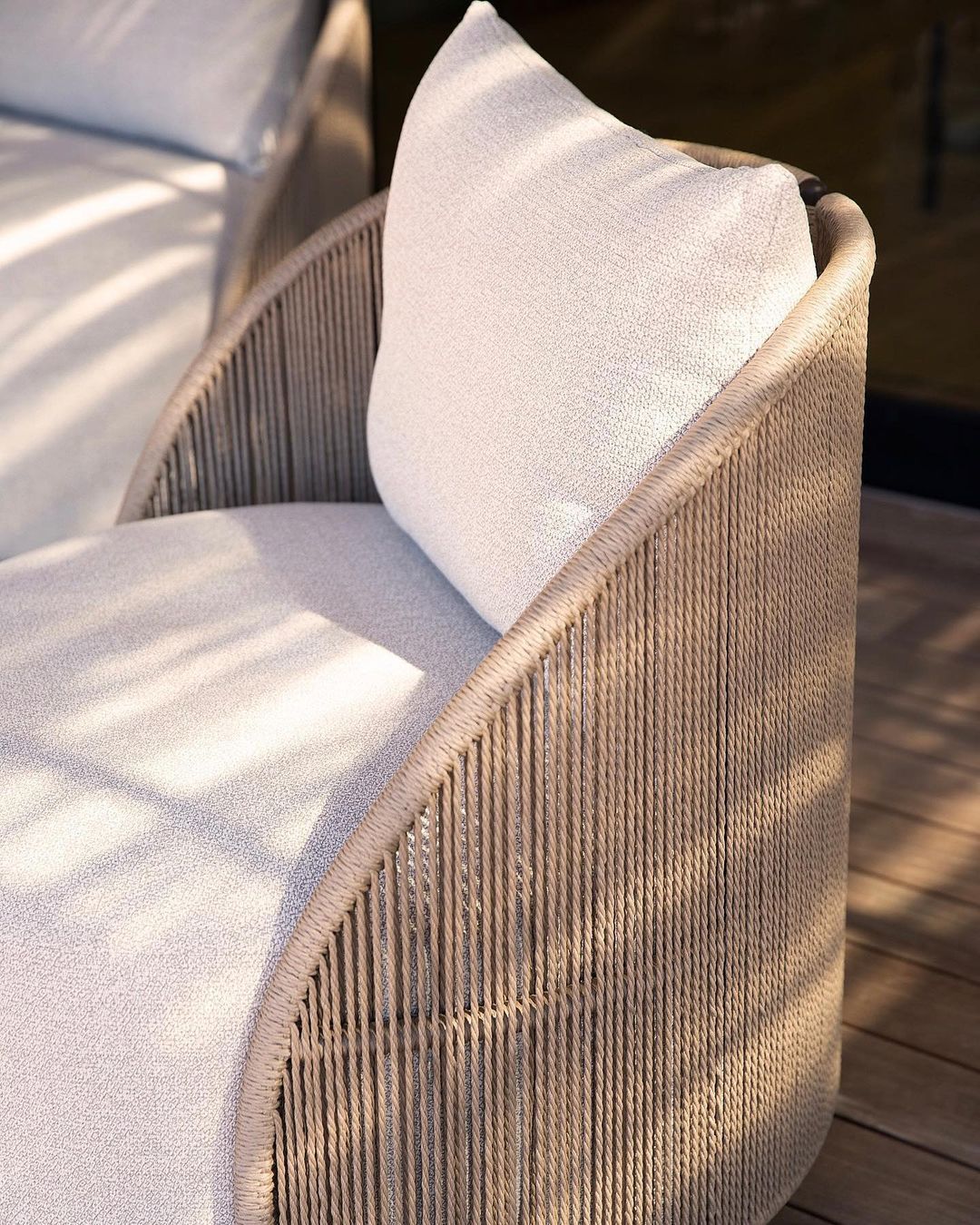Detail shot of Corda chair arm — woven rope wrap and linen cushion junction — Minosé