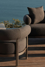 Load image into Gallery viewer, Rocchetto outdoor lounge chair in cream boucle — sculptural bolster form — desert garden setting — Minosé
