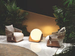 Load image into Gallery viewer, Nicchia lounge chair in cream linen — woven back panel — garden setting with accent lighting — Minosé
