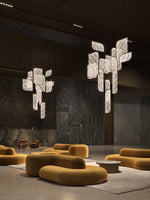 Load image into Gallery viewer, Foglia modular pendant lights — clustered arrangement in light finish — suspended in interior space with golden seating — Minosé
