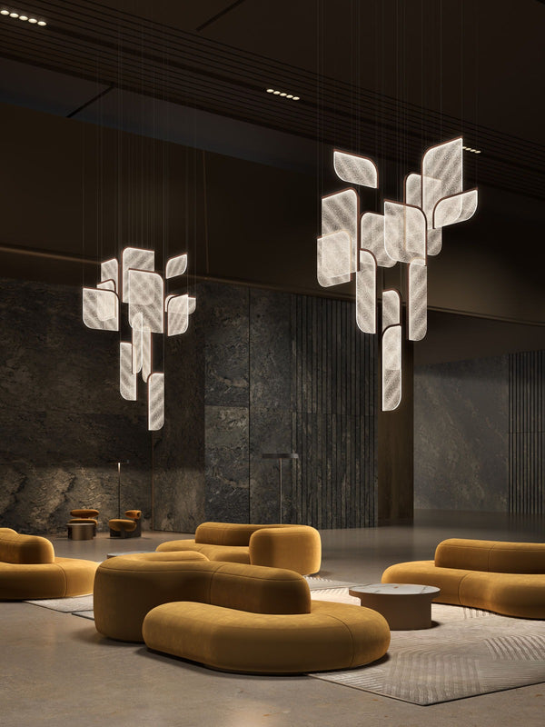 Foglia modular pendant lights — clustered arrangement in light finish — suspended in interior space with golden seating — Minosé