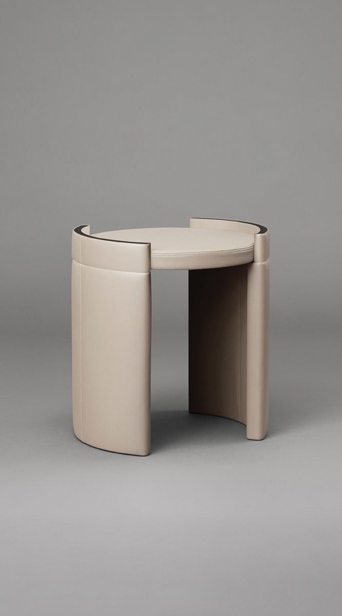 Luxury sculptural side table with curved leather panels and dark wood finish by minosé