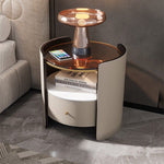 Load image into Gallery viewer, Luxury bedside table with smoked glass top, curved leather panels, and drawer storage by Minosé
