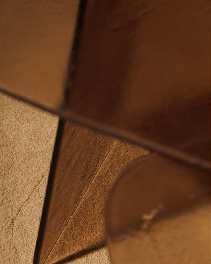 Luxury smoked glass sculptural side table with warm bronze tones by Minosé