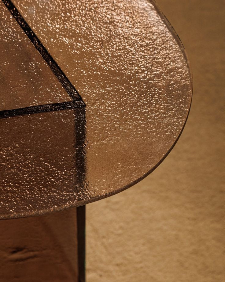 Luxury smoked glass sculptural side table with warm bronze tones by Minosé